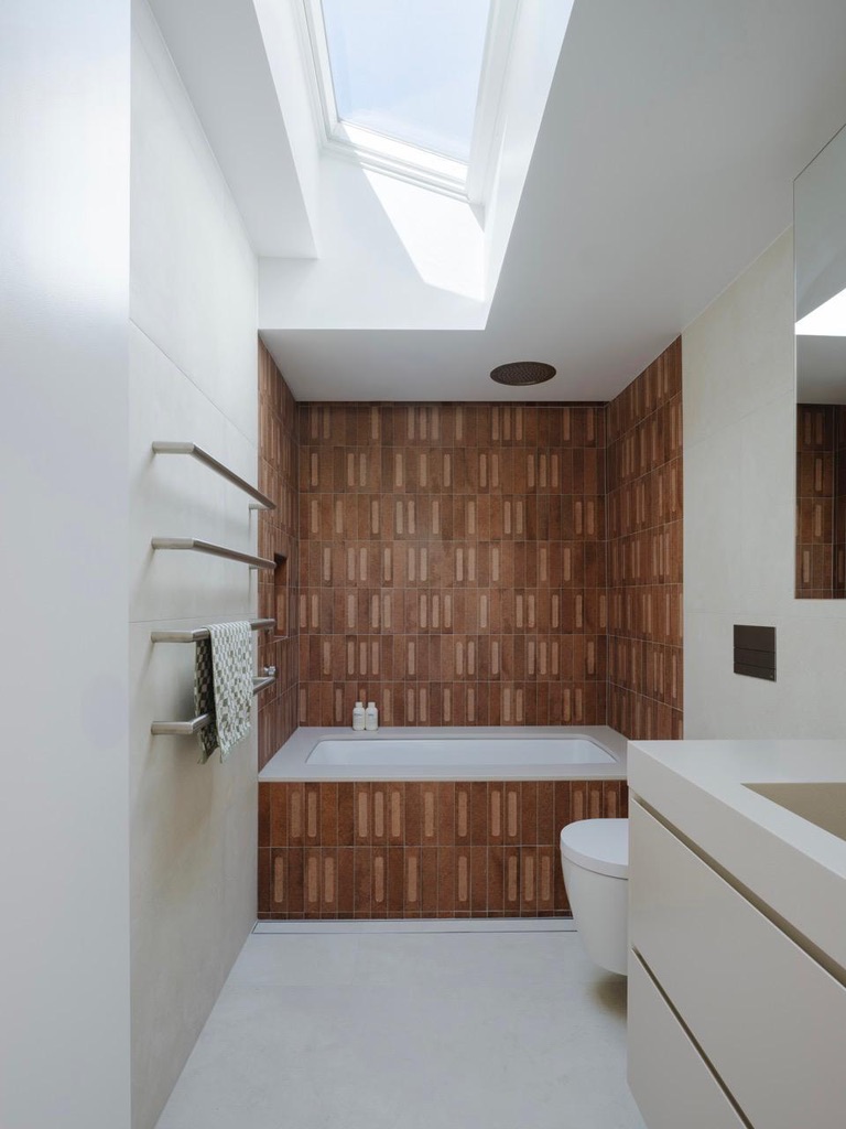 Bathroom — terracotta tiles, skylight above bath